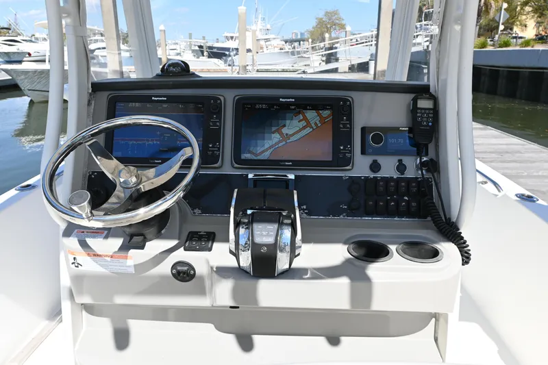 Slide: The Image of 2014 Boston Whaler 270 Dauntless boat dashboard with steering wheel and navigation screens. - 8