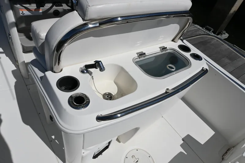 Slide: The Image of 2014 Boston Whaler 270 Dauntless boat console with sink and storage compartments. - 9
