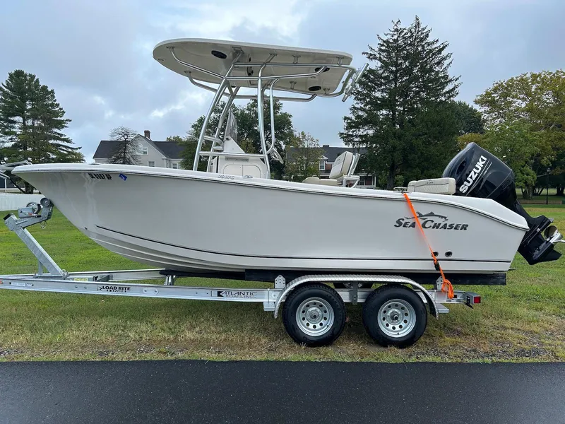 The Image of 2022 Sea Chaser 20 HFC boat on trailer, parked on grass, overcast sky. - 0