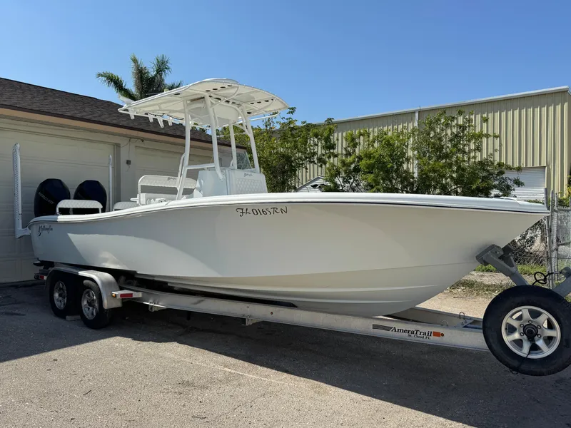 Slide: The Image of 2015 Yellowfin 26 boat on trailer, parked outdoors near a garage. - 0