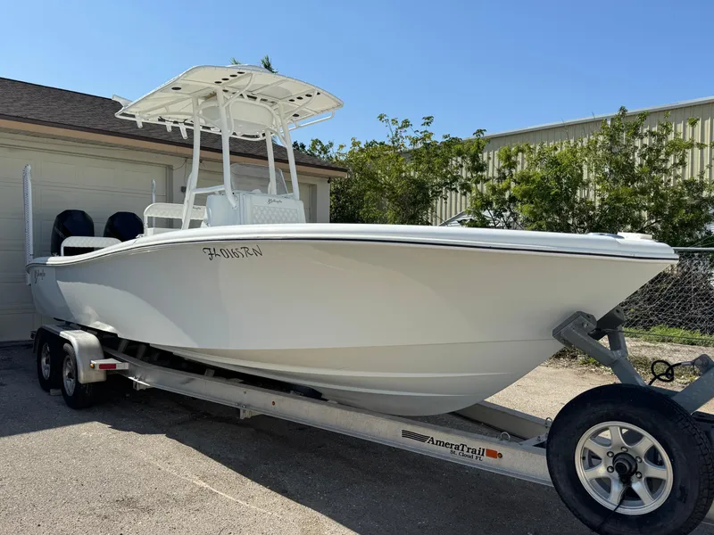 Slide: The Image of 2015 Yellowfin 26 boat on trailer, parked outdoors, clear sky background. - 1