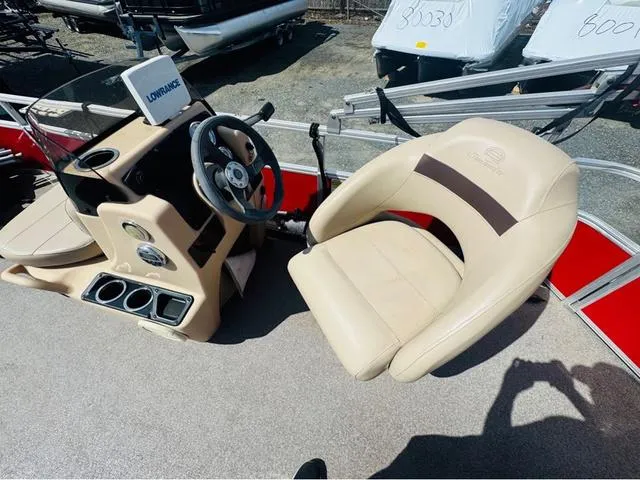 Slide: The Image of 2017 Tracker Bass Buggy 18 DLX boat interior with steering console and beige seating. - 8
