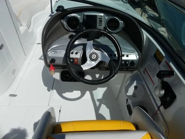 Slide: The Image of 2011 SouthWind 2400 Bowrider boat cockpit with steering wheel and dashboard controls. - 6