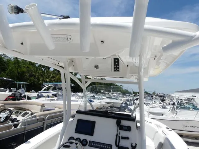Slide: The Image of 2019 Sea Fox 266 Commander boat console with electronics, surrounded by other boats in a marina. - 16