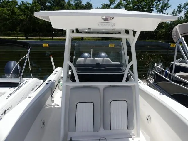 Slide: The Image of 2019 Sea Fox 266 Commander boat with T-top and seating, docked near other boats. - 20