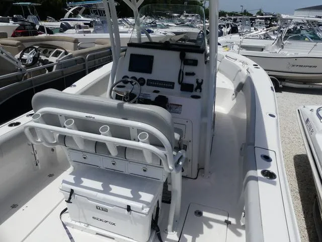Slide: The Image of 2019 Sea Fox 266 Commander boat interior with console and seating, docked among other boats. - 7