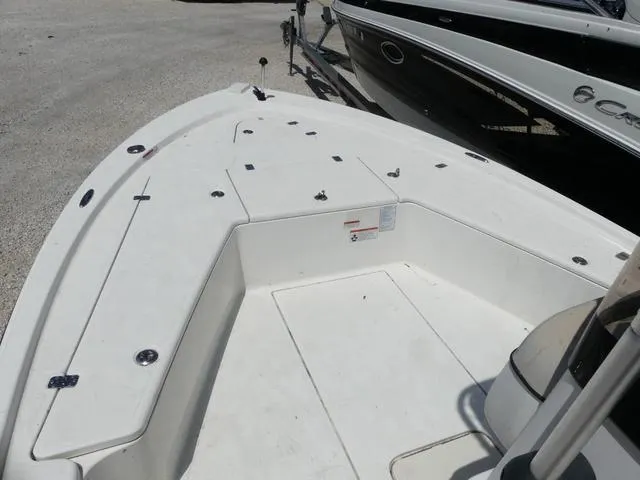 Slide: The Image of 2017 Mako 21 LTS boat deck, spacious and clean, parked beside another vessel. - 10