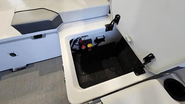 Slide: The Image of 2023 Yamaha Boats AR 220 storage compartment with open hatch, showcasing interior details. - 24
