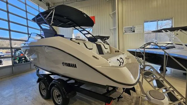 Slide: The Image of 2023 Yamaha Boats AR 220 in showroom, featuring sleek design and dual-axle trailer. - 4