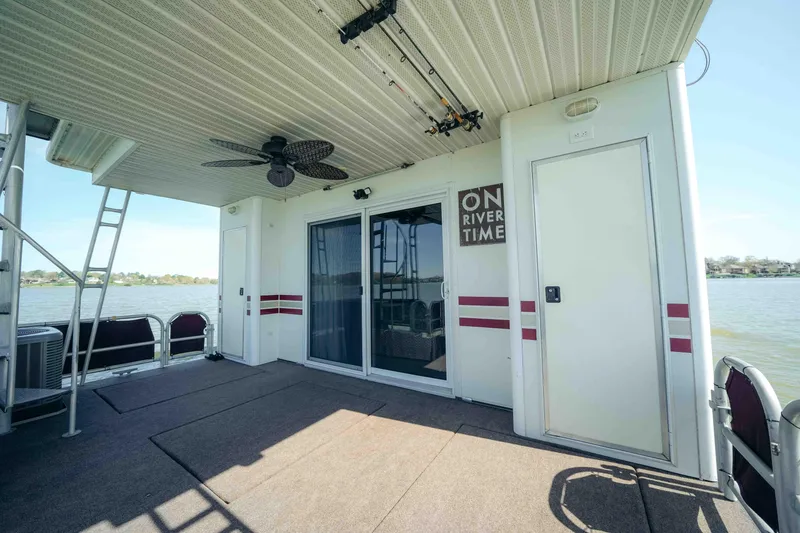 Slide: The Image of 1999 Sumerset houseboat deck with sliding doors, ceiling fan, and river view. - 11