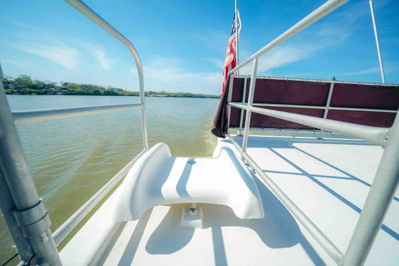 Slide: The Image of 1999 Sumerset houseboat deck with slide, railing, and American flag on a sunny day. - 15