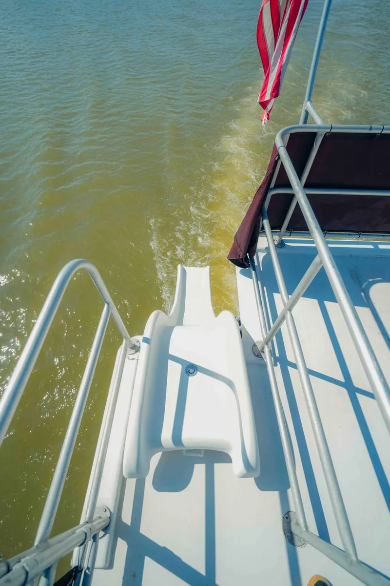 Slide: The Image of 1999 Sumerset houseboat with slide, American flag, and water view. - 16
