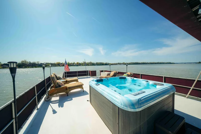 Slide: The Image of 1999 Sumerset houseboat deck with hot tub, seating, and scenic river view. - 18