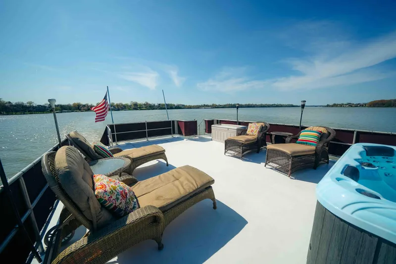 Slide: The Image of Sunny deck of 1999 Sumerset houseboat with loungers and hot tub on a serene lake. - 21