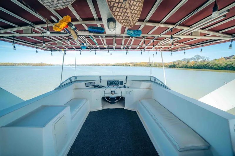 Slide: The Image of 1999 Sumerset houseboat interior with seating, steering wheel, and lake view. - 23
