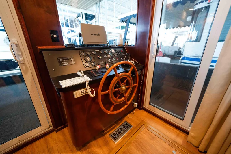 Slide: The Image of 1999 Sumerset houseboat helm with wooden steering wheel and navigation equipment. - 29