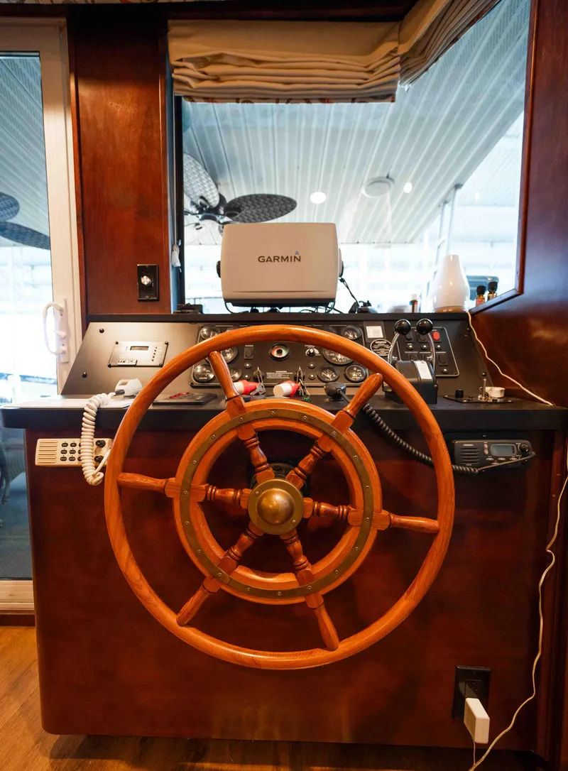 Slide: The Image of 1999 Sumerset houseboat helm with wooden steering wheel and Garmin navigation system. - 30