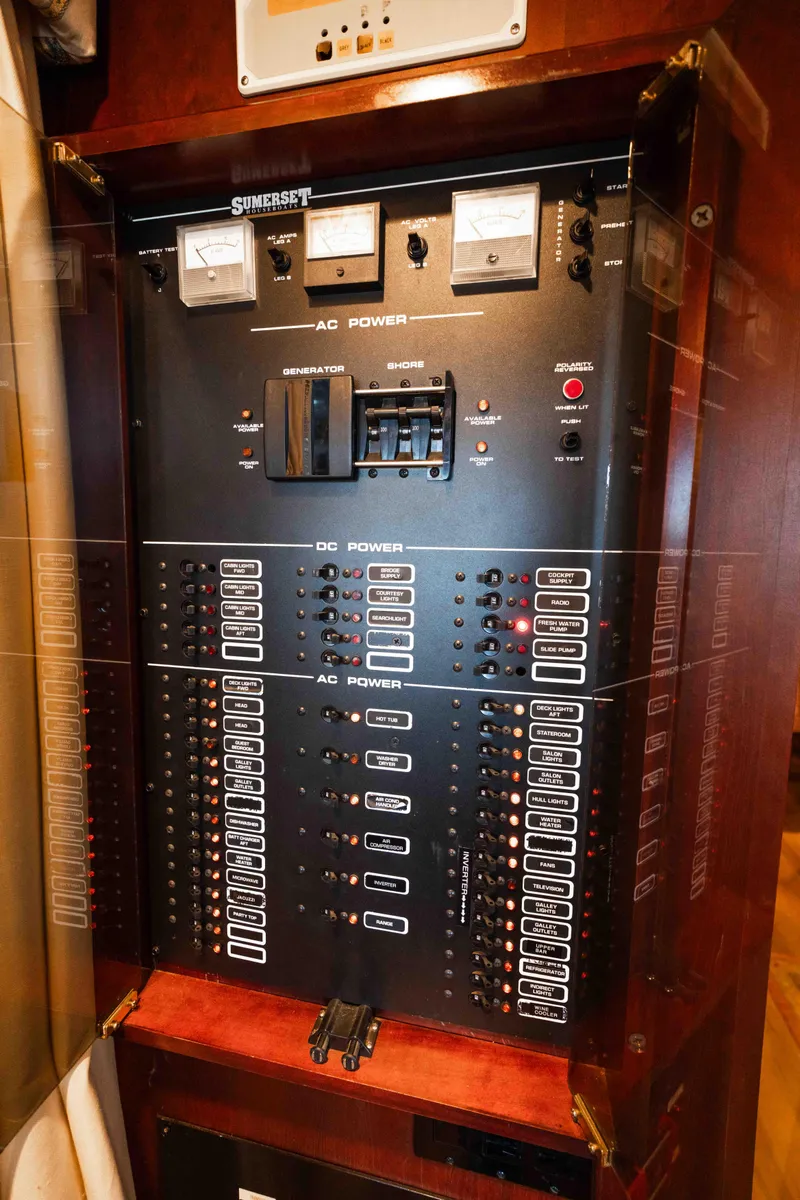 Slide: The Image of Electrical control panel on a 1999 Sumerset houseboat, featuring AC and DC power switches. - 36