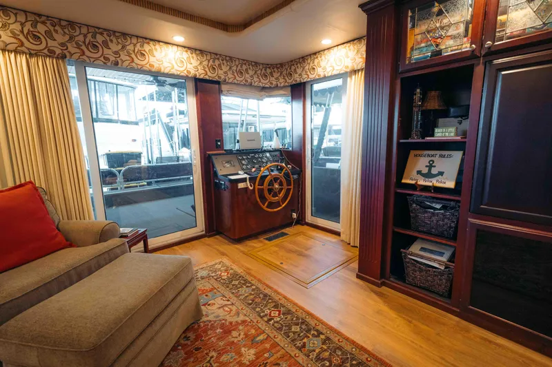 Slide: The Image of 1999 Sumerset houseboat interior with helm, cozy seating, and elegant wood cabinetry. - 41