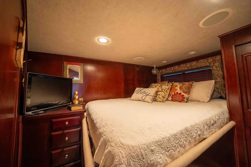 Slide: The Image of Cozy bedroom in 1999 Sumerset houseboat with TV, wooden decor, and plush bedding. - 47