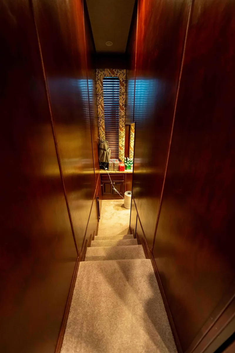Slide: The Image of Narrow hallway with wooden walls and carpeted stairs on a 1999 Sumerset houseboat. - 48