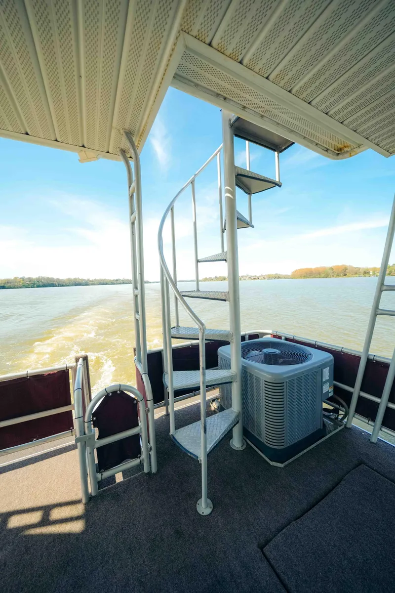 Slide: The Image of 1999 Sumerset houseboat on a calm river, surrounded by lush greenery. - 5
