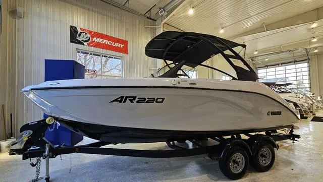 Slide: The Image of 2023 Yamaha Boats AR 220 in showroom, sleek design, on trailer. - 1