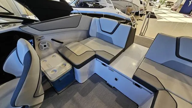 Slide: The Image of 2023 Yamaha Boats AR 220 interior with gray seating and built-in cooler. - 10