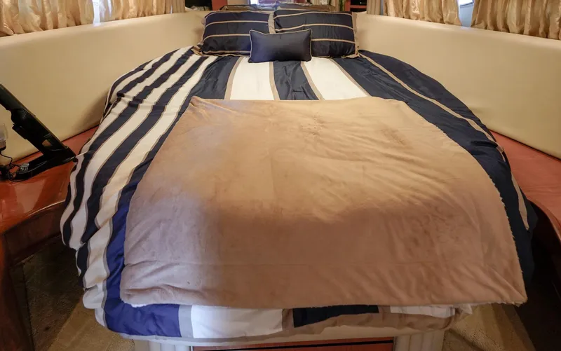 Slide: The Image of Cozy bedroom in 2000 Sea Ray 510 Sundancer yacht with striped bedding. - 15