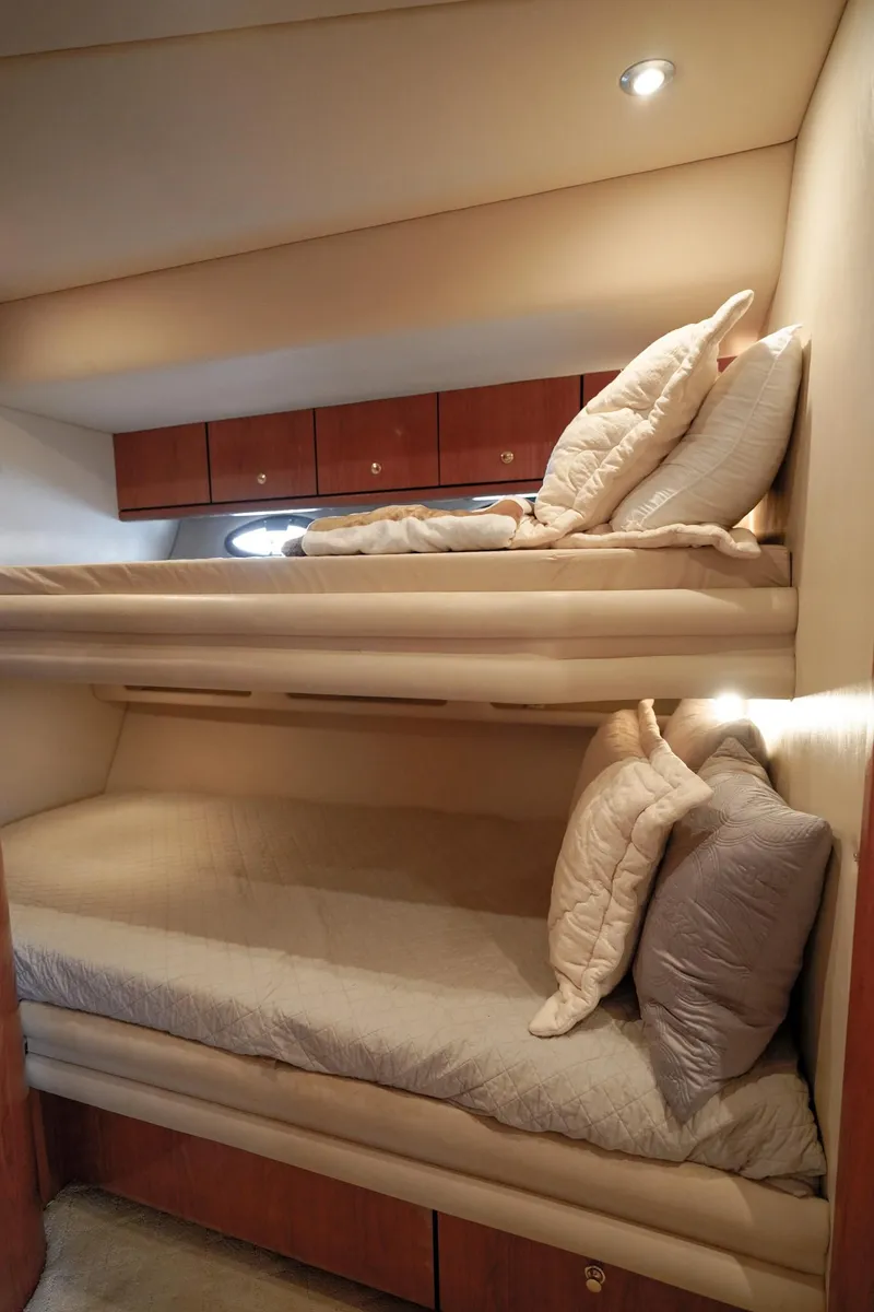 Slide: The Image of 2000 Sea Ray 510 Sundancer cabin with cozy bunk beds and wooden storage cabinets. - 22