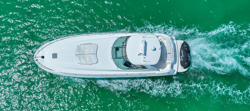 Slide: The Image of Aerial view of 2000 Sea Ray 510 Sundancer cruising on turquoise water. - 48