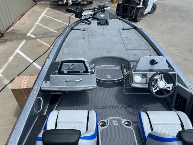 Slide: The Image of 2025 Caymas CX21 Pro boat interior with steering wheel and seating, docked in a marina. - 13