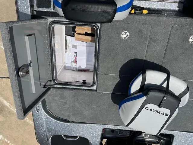 Slide: The Image of 2025 Caymas CX21 Pro boat interior with open storage compartment and branded seat. - 27