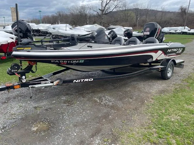 Slide: The Image of 2013 Nitro Z-6 boat on trailer, parked outdoors, with overcast sky. - 2
