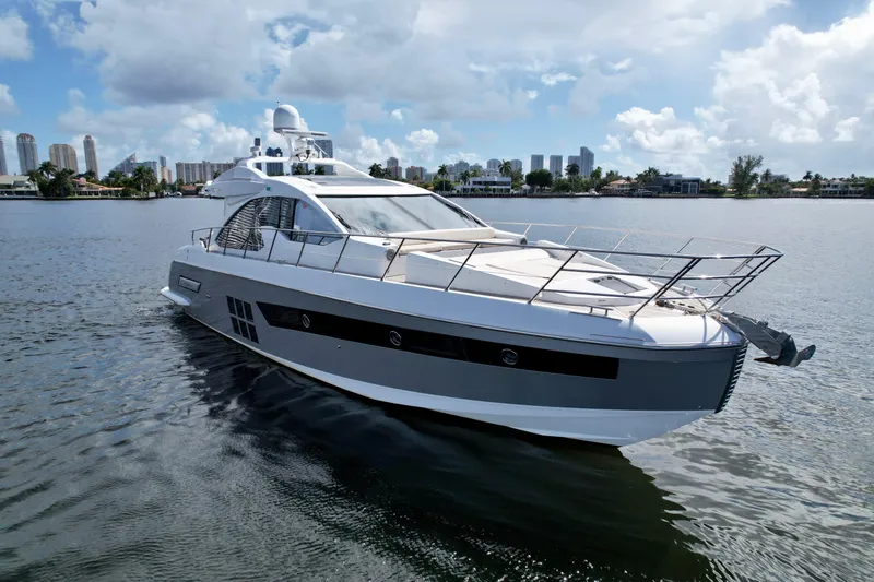 Slide: The Image of 2015 Azimut 55S yacht cruising on a calm waterway under a partly cloudy sky. - 0