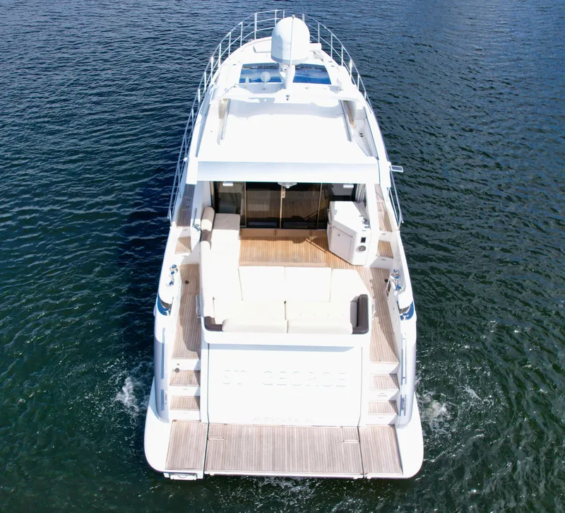 Slide: The Image of 2015 Azimut 55S yacht on open water, rear view showcasing deck and seating area. - 14