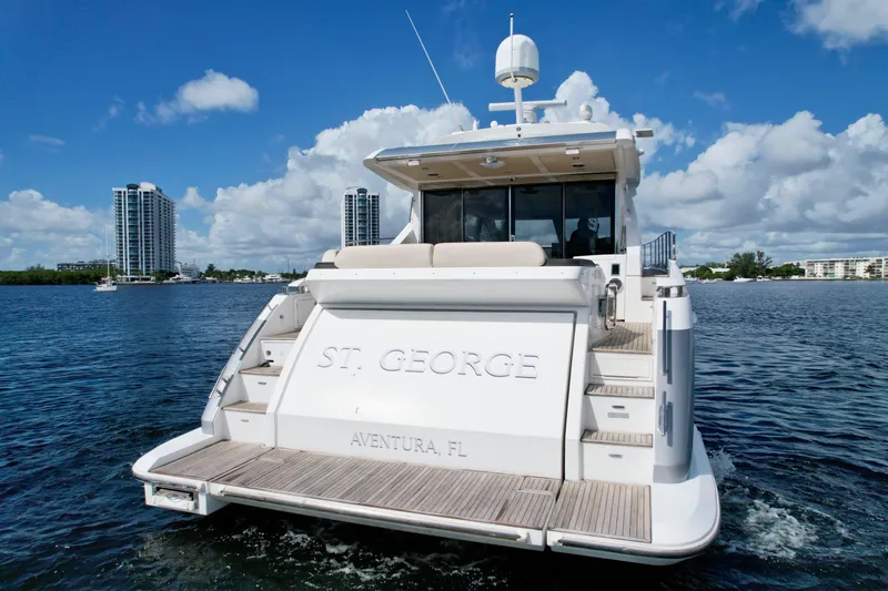 Slide: The Image of 2015 Azimut 55S yacht on water, rear view, with city skyline in background. - 15