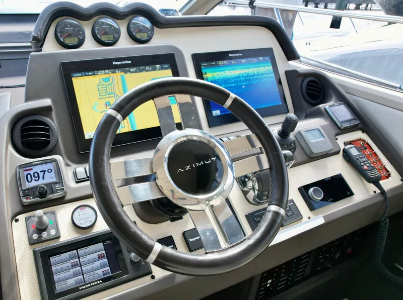 Slide: The Image of Control panel of a 2015 Azimut 55S yacht with navigation screens and steering wheel. - 43