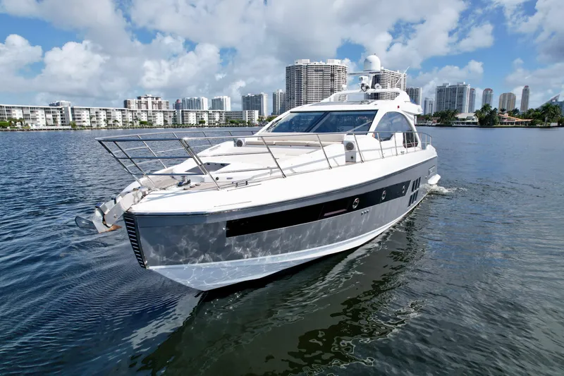 Slide: The Image of 2015 Azimut 55S yacht cruising on a sunny day with city skyline backdrop. - 5
