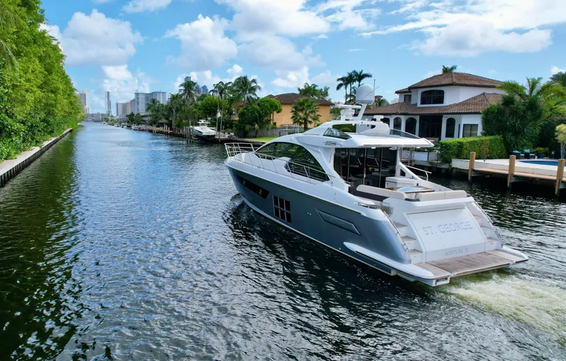 Slide: The Image of Luxurious 2015 Azimut 55S yacht cruising through a scenic canal with waterfront homes. - 9