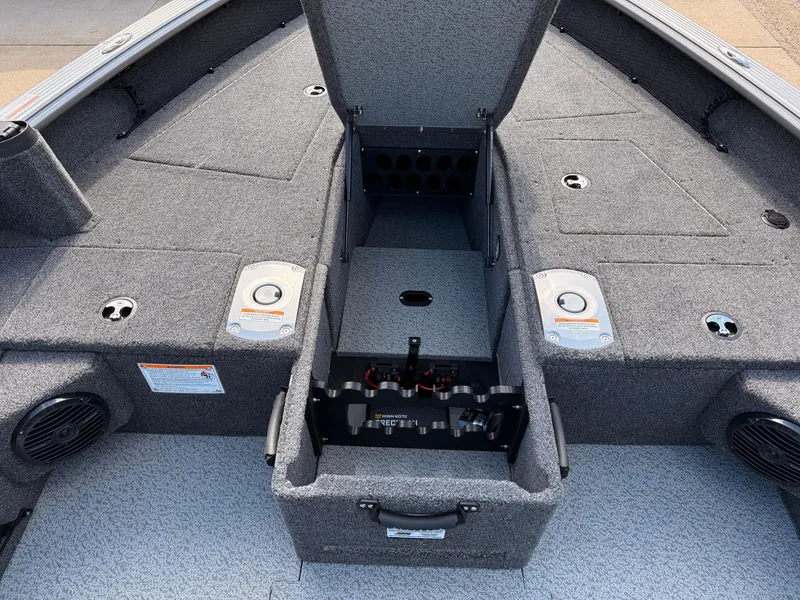 Slide: The Image of 2025 Lund 1875 Pro Guide boat interior with open storage compartment and gray carpeting. - 11