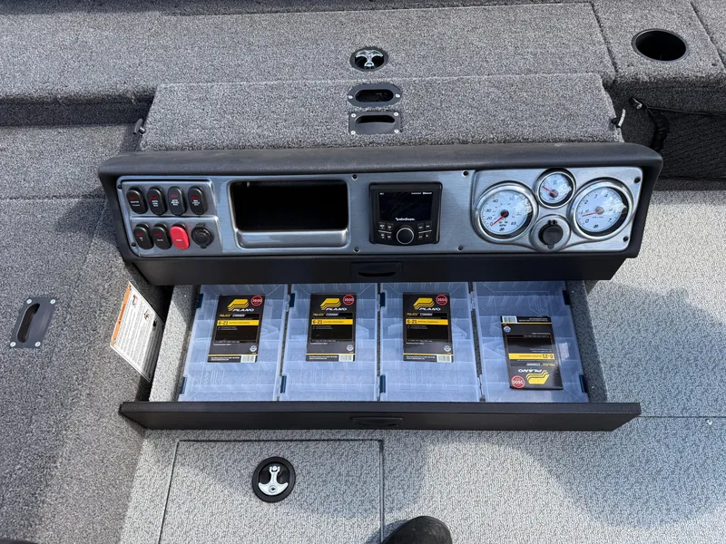 Slide: The Image of 2025 Lund 1875 Pro Guide boat dashboard with storage drawer and organized tackle boxes. - 20