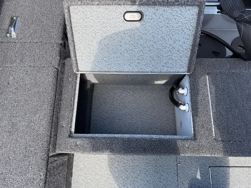 Slide: The Image of Open storage compartment in 2025 Lund 1875 Pro Guide boat, featuring gray interior. - 23