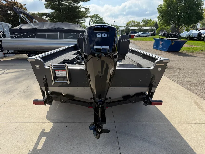 Slide: The Image of 2025 Lund 1875 Pro Guide boat with Mercury 90 engine, parked outdoors. - 6