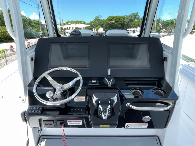 Slide: The Image of 2025 Everglades 315 Center Console boat dashboard with dual screens and steering wheel. - 17