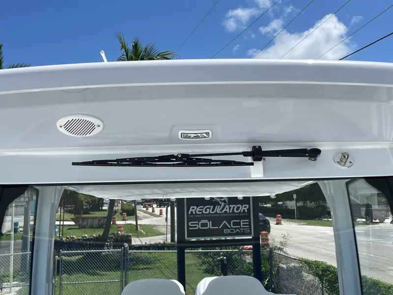 Slide: The Image of 2025 Everglades 315 Center Console boat windshield with wiper and speaker, outdoor setting. - 34