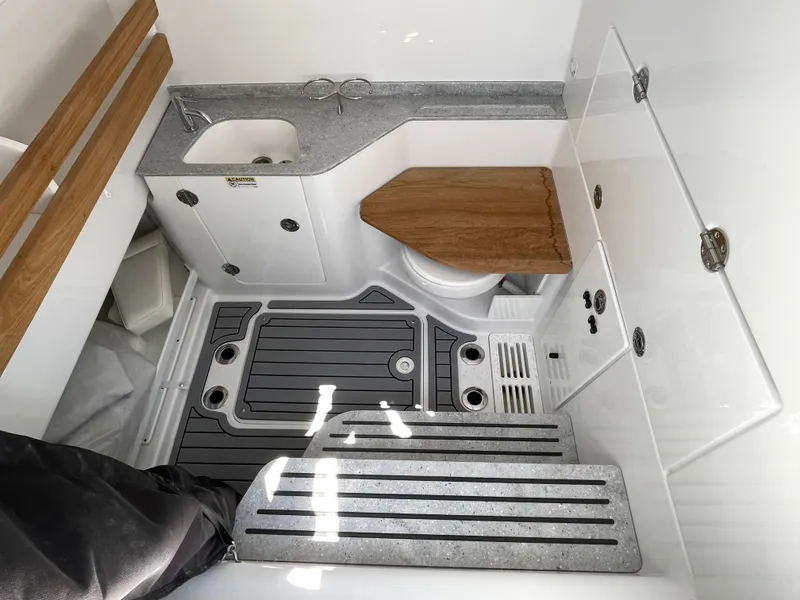 Slide: The Image of 2025 Everglades 315 Center Console boat interior with sink, toilet, and wooden accents. - 41