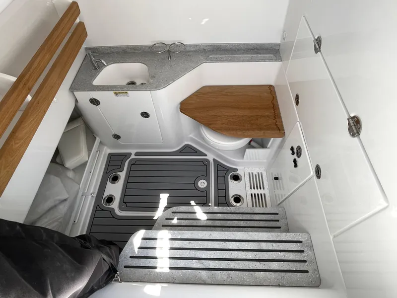 Slide: The Image of 2025 Everglades 315 Center Console boat interior with sink, toilet, and wooden accents. - 42