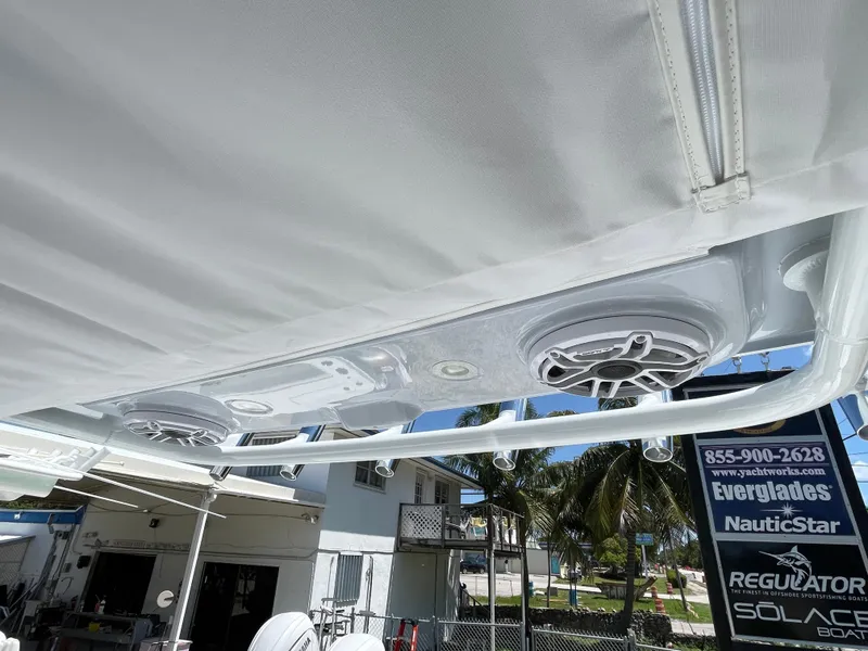 Slide: The Image of 2025 Everglades 315 Center Console boat speakers under canopy, outdoor setting. - 44