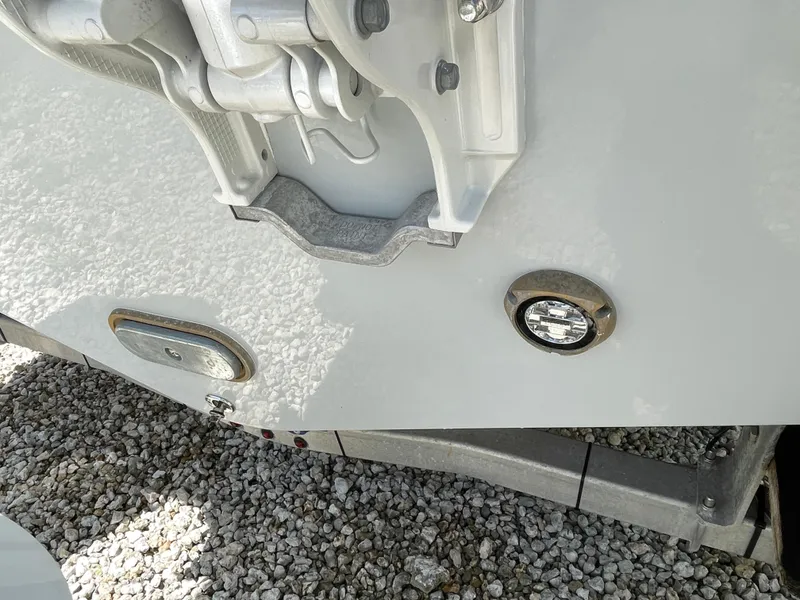 Slide: The Image of 2025 Everglades 315 Center Console boat detail on gravel, showcasing hull and fittings. - 6